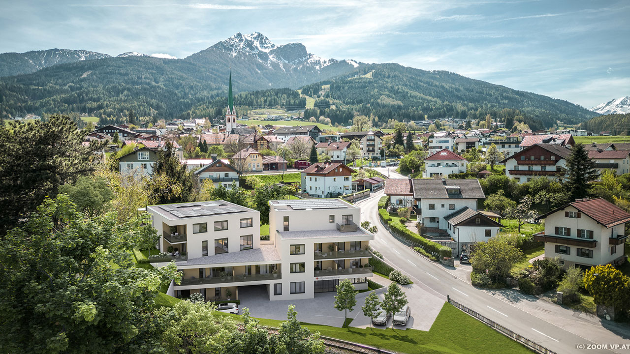 Ansicht eines Gebäudes im Grünen mit Blick auf die Berge